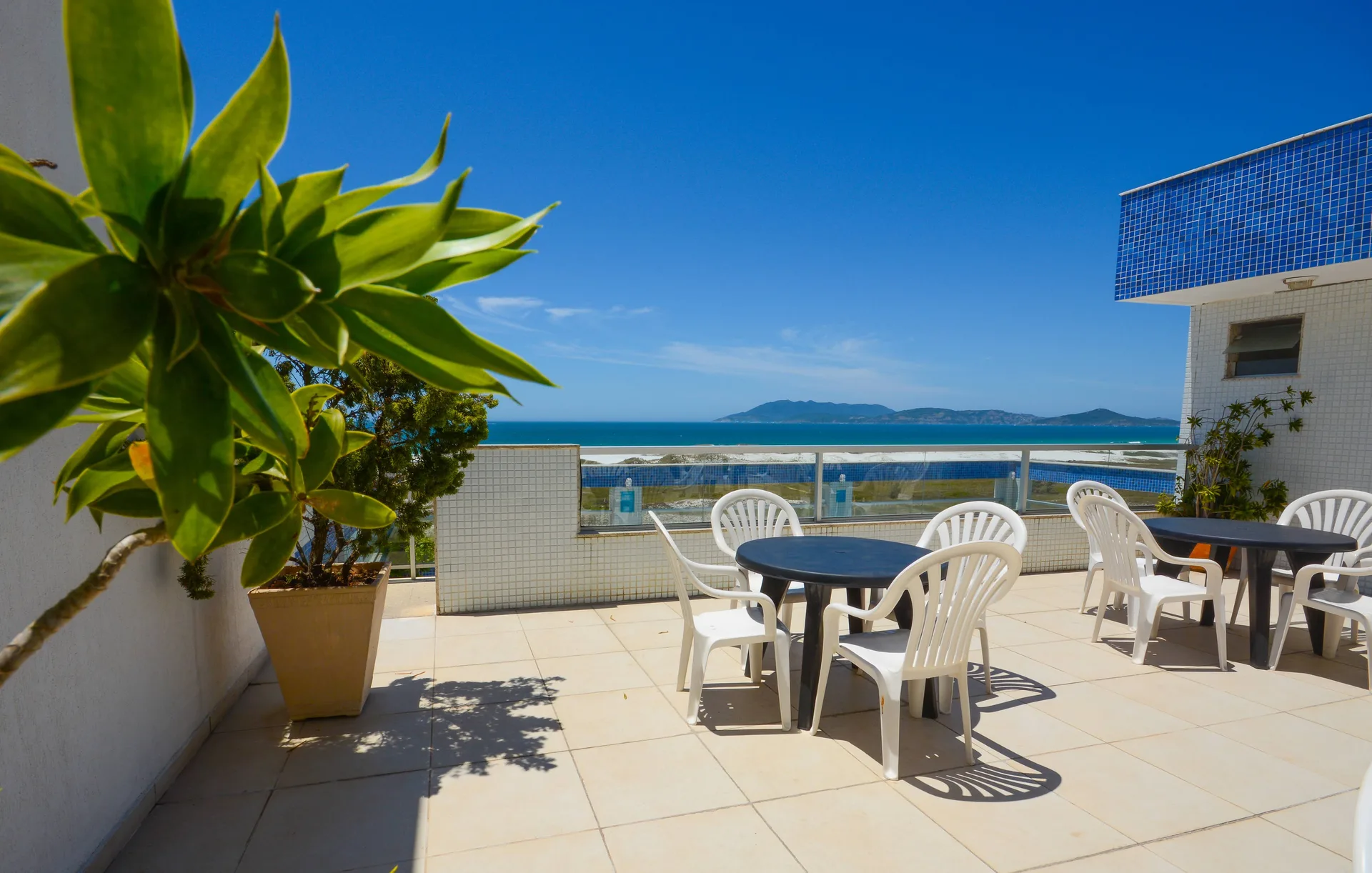 Solário na cobertura do hotel com mesas e vista para o mar de Cabo Frio
